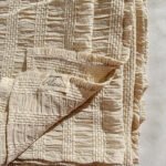 Top stitched beige bed throw